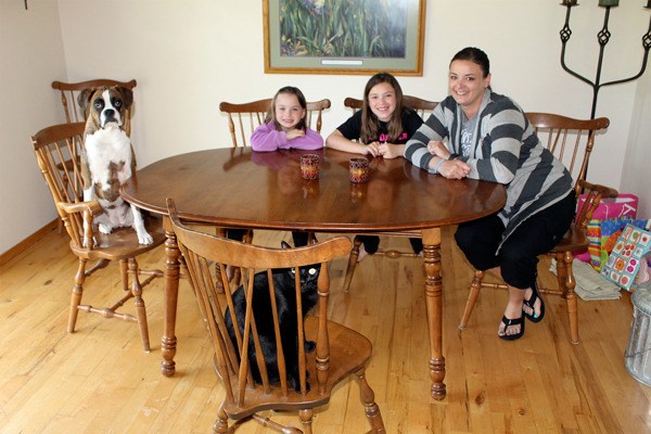 Lulu the dog sits at the family table with owners Gretta