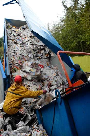 Island Recycling workers Susie and Yu Williams guide paper into a compacting machine.