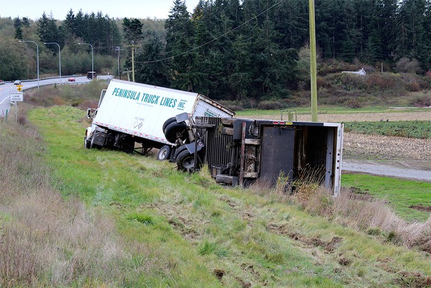 A trailer rests on its side after a semi-truck went off the road of Highway 20 on Thursday morning.