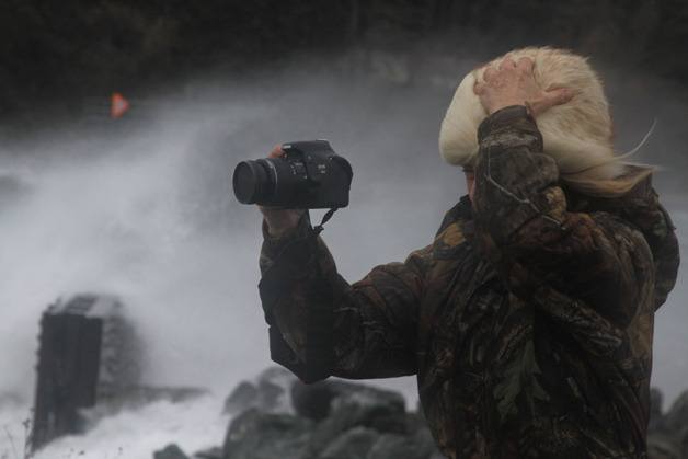 A photographer captures the stormy weather and holds on to her hat at the Coupeville ferry landing Thursday afternoon