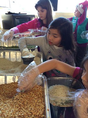 Chloe Goethel and Kristen Riley create dried-soup mixes on behalf of the South Whidbey Girl Scouts’ Food Drive. The food drive donates the mixes to the Good Cheer Food Bank.