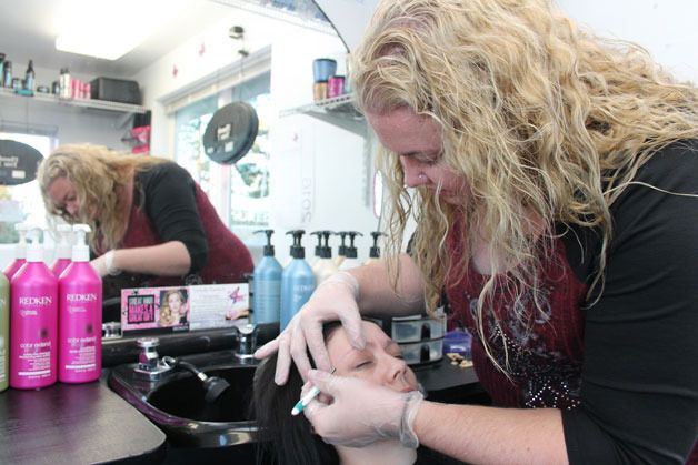 Alicia Clancy tweezes customer Bridgit Howard's eyebrows during a recent visit to the one-chair salon in Clinton. The Freeland woman opened the business in a former espresso stand along the highway near the ferry terminal.