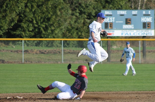 Falcon junior shortstop Ricky Muzzy leaps over a Coupeville runner as he slides into second base March 17 at South Whidbey High School.