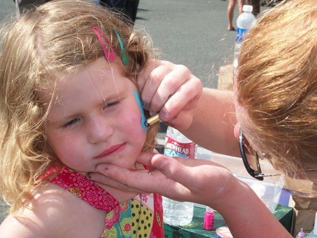A girl sits through some face painting at the 2012 Choochokam Arts festival.