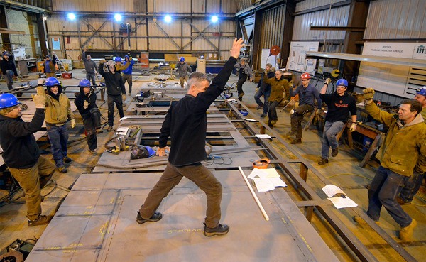 Adam Fawcett leads an early beginning-of-the-day exercise routine at Nichols Brothers Boat Builders in Freeland. The program is mandatory and cut injuries by half.