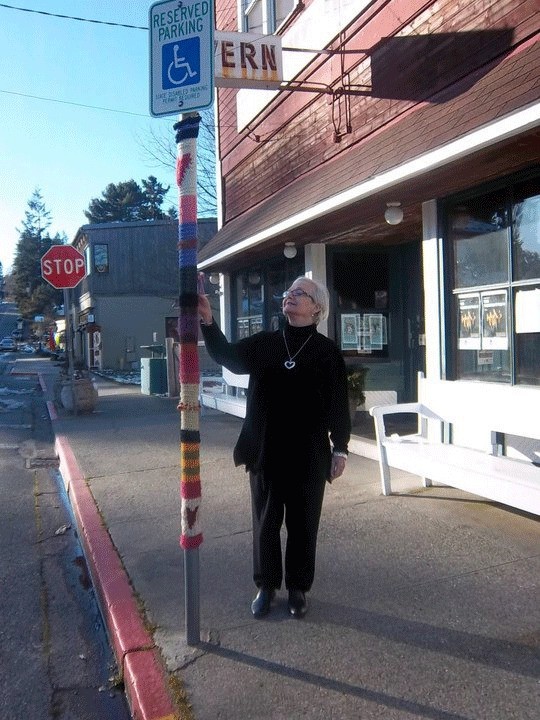 Josh Hauser stands next to a sign pole that was hit by the yarn bombers.