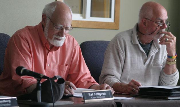 Langley councilmen Hal Seligson and Bruce Allen listen to Mayor Fred McCarthy discuss the city's termination of its legal contract with Kenyon Disend while they review their council meeting packets.