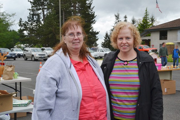 Jan Quade and Mary Posz stand in front of the garage sale benefitting Quade. The sale raised more than $1