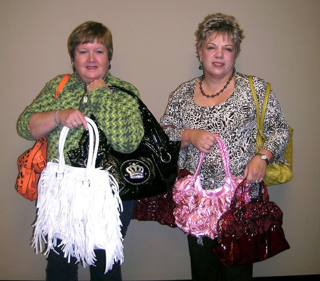 Event co-chairwoman Lisa Grosso and Soroptimist International of South Whidbey Island president Sheila White hold up a small sample of the purses to be filled with goodies at the Purses with a Purpose fundraiser.
