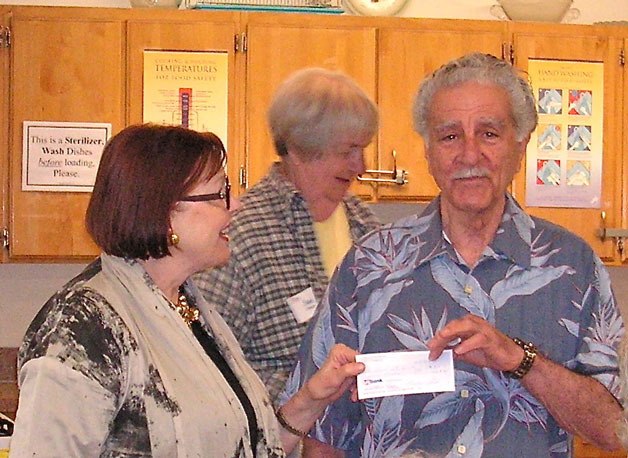 Ginger Schmidt presents Frank Rose and the Whidbey Island Arts Council with a check for $700.