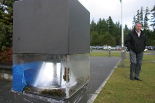Dan Poolman inspects several light posts along the causeway to South Whidbey Elementary School. Duct tape holds the casing in place.