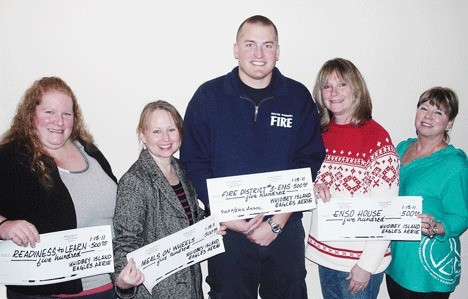 Accepting the donations (pictured at right) are Ann Johnson of the Readiness to Learn Foundation; Debbie Metz of the Island County Senior Services program Meals on Wheels; and Jimmy Berto