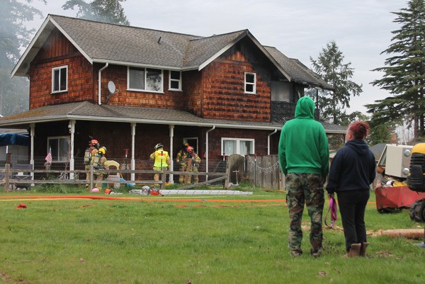 South Whidbey Fire/EMS firefighters prepare to inspect the inside of a Clinton home after beating back the flames