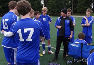 Falcon assistant soccer coach Emerson “Skip” Robbins speaks to the junior varsity team before a match.