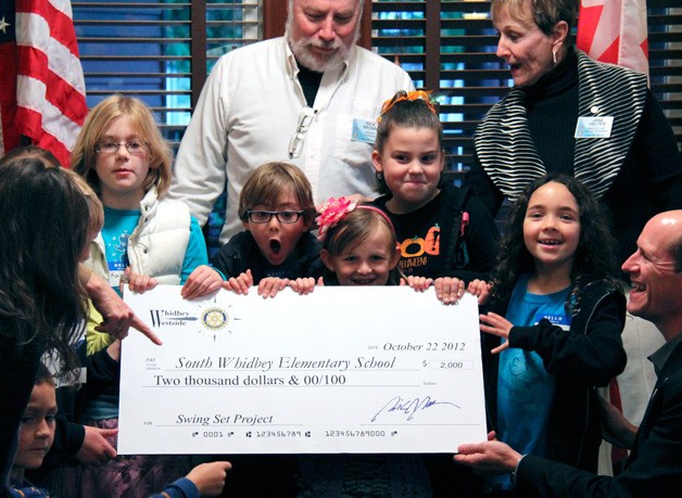 Students from Laura Anthony’s first- and second-grade class clamor for a check from the South End’s Rotary club