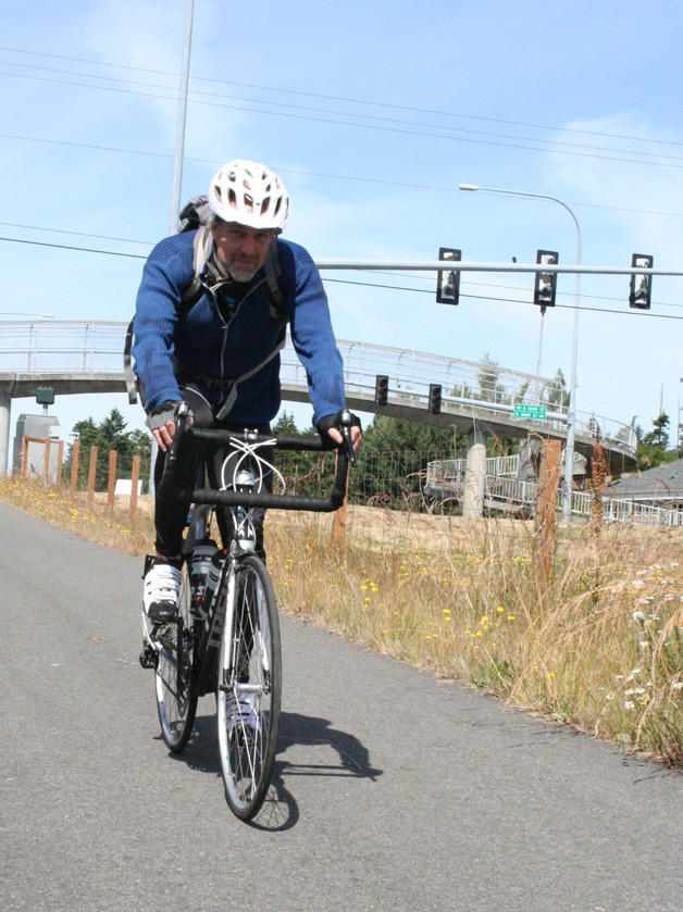 Pat Rodden pedals along the Rhododendron Trail in Coupeville on a recent sunny day. The Coupeville man used the Warm Showers network of hospitality exchange on some of his bicycling journeys.