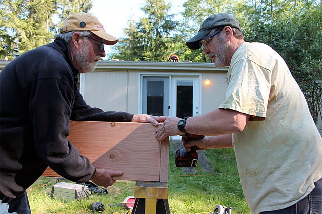 Volunteers Chris Spencer (left) and Dave Earp (right) build a garden box for a disabled homeowner during Saturday’s Hearts & Hammers workday.