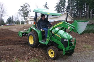 Angus Buchanan spreads the soil in front of Good Cheer headquarters that will be used for raised vegetable beds. The project is expected to be completed next month.