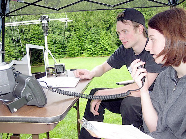 Last year South Whidbey High School students Sean McDougald and Megan Jeffers listened intently for amateur radio stations via satellite during a national radio emergency  preparedness event at South Whidbey Community Park. The two radio hams will be among numerous Whidbey residents who will test their communications skills again this year.