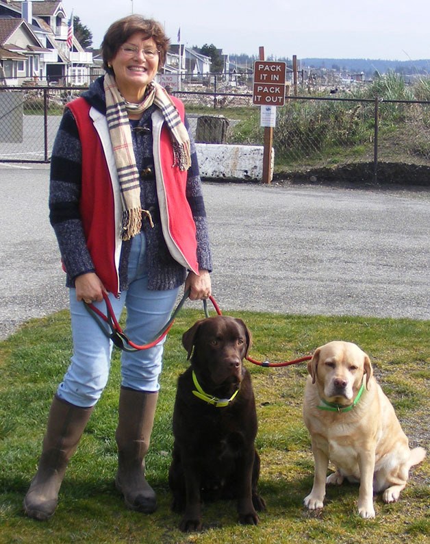Painter Cary Jurriaans walks her dogs at a Whidbey area beach.  The artist became the first woman accepted to the Puget Sound Group of Northwest Painters in 80 years.