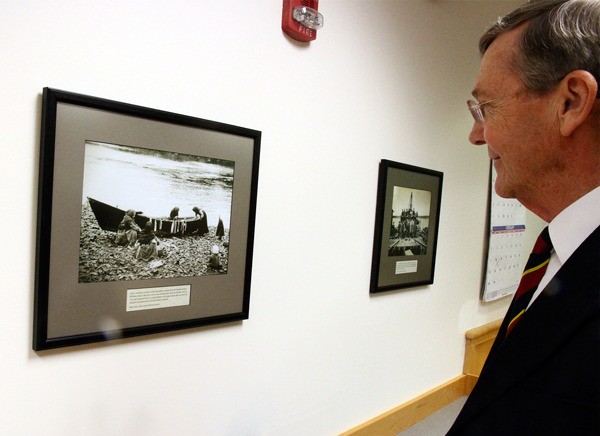 Island County Superior Court Judge Alan Hancock looks at one of many historical photos recently hung to decorate the walls of his courtroom. The were presented in a public ceremony on Monday.