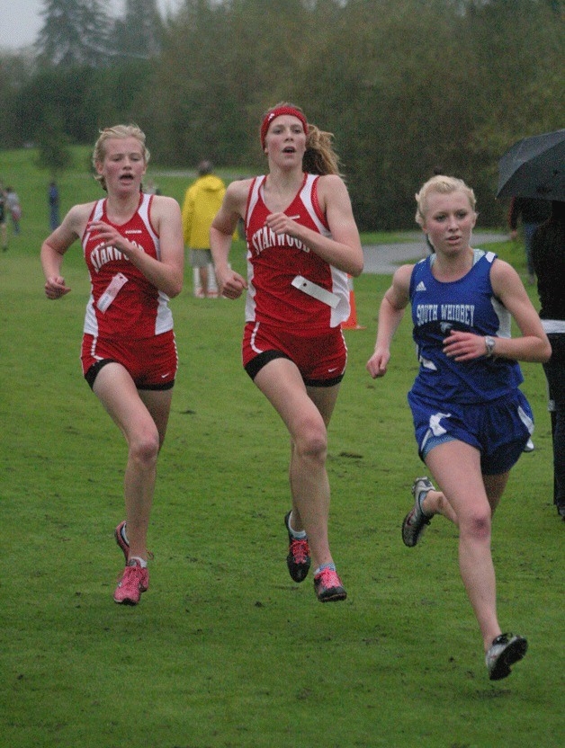 Lillianna Stelling sprints toward the finish to pass a duo of racers from Stanwood. Stelling finished 10th in the sophomore class race in 20 minutes