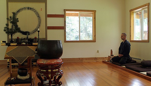 Kozan meditates in the zendo (meditation hall) Monday morning. On the altar in the center of the room lie the ashes of two teachers. The circular symbol
