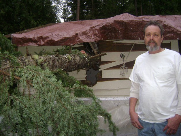 Clinton resident Craig Brooks poses for a picture in front of his house