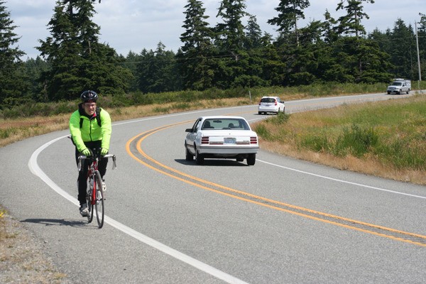 A commuter bicycles north on Highway 20 on Central Whidbey. Island County is working on a plan for a roughly 20-mile bike loop on South Whidbey
