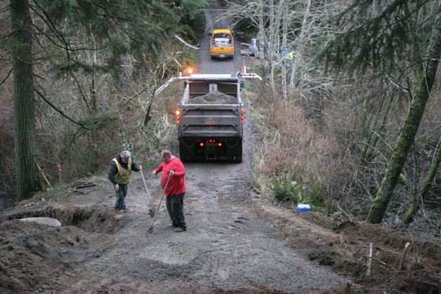 Workers spread gravel across Frog Water Road during the installation of a new culvert system to protect the road from washing out. Island County crews have been at the site around the clock since Jan. 5