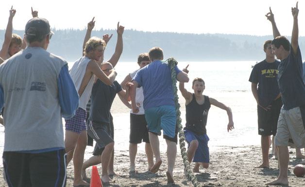 Falcon football players cheer as their teammate finishes a relay while dragging a 20-pound ferry rope at Double Bluff beach on Thursday.