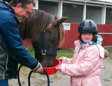 HOPE Therapeutic Riding Center volunteer Marshall McElveen introduces Talia Petosa to her new best friend last Thursday at Island County Fairgrounds.
