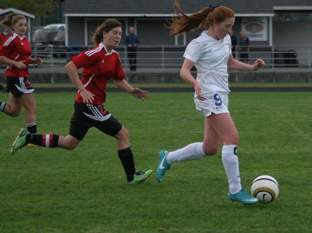 South Whidbey senior Madi Boyd passes two Coupeville defenders during the girls soccer game Sept. 24.
