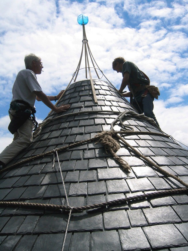 Builders put the finishing touches on the rubber 'slate' roof of the Maxwelton Creek house turret.