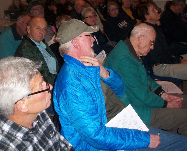 Clinton resident Jack Lynch asks a question to David Moseley as others in the crowd listen.