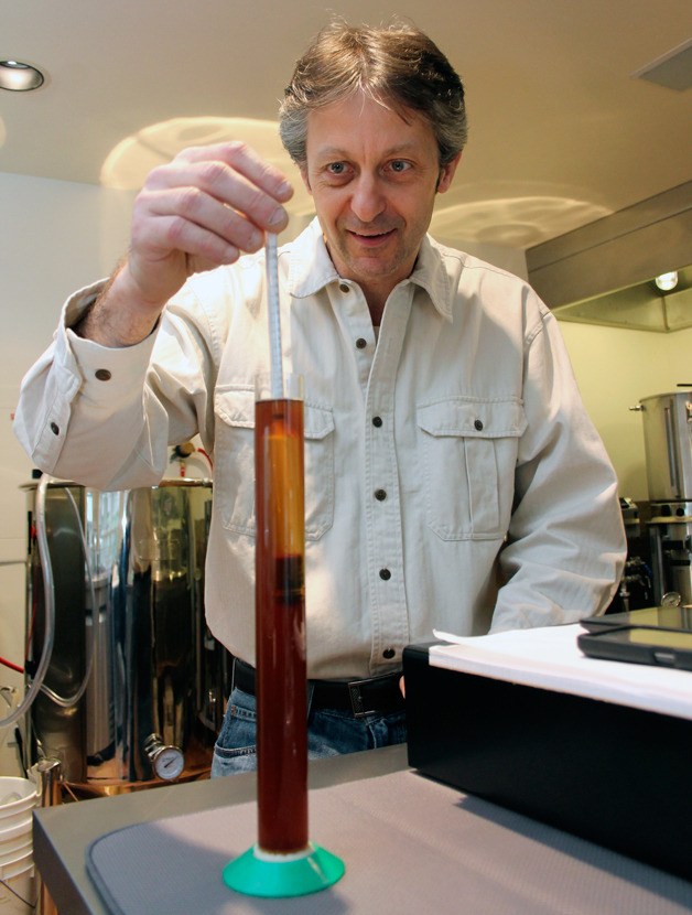 Daniel Thomis inspects the gravity of one of his concoctions at Double Bluff Brewing Company