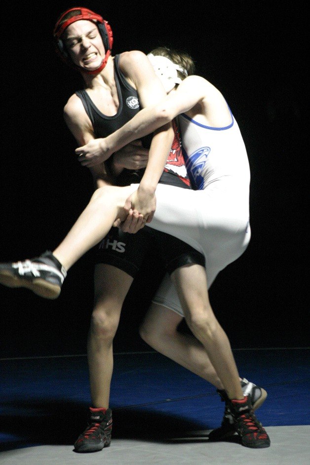 Wildcat freshman Kenny Ficklin tries to escape and lift 106-pound Falcon freshman Steven Smith on Monday.
