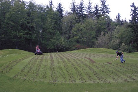 Bill Mannello and Paul Olmi aerate a section of the Holmes Harbor Golf Course on Thursday. The course was closed by its owner in March