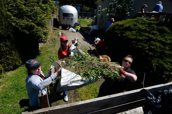 Volunteers haul yard debris into a dumpster during the Hearts & Hammers work day earlier this year. Held the first Saturday of each May on South Whidbey