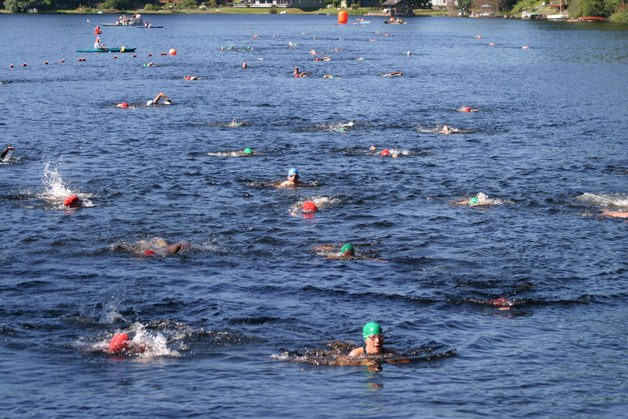 Racers swim to shore at Goss Lake in the 2012 Whidbey Island Triathlon. Organizers with the South Whidbey Parks and Recreation District estimate about 250 racers for the triathlon today.
