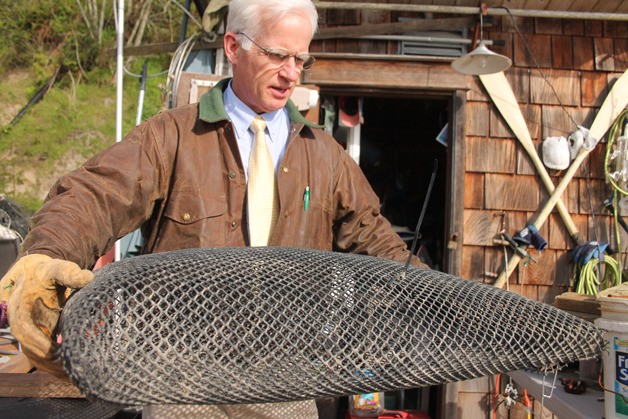 Kevin Lungren holds an oyster bag at his house on Holmes Harbor.