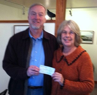 Langley Community Club President John Lawson hands a check for $300 to Langley Main Street Association Program Manager Lorinda Kay in October.