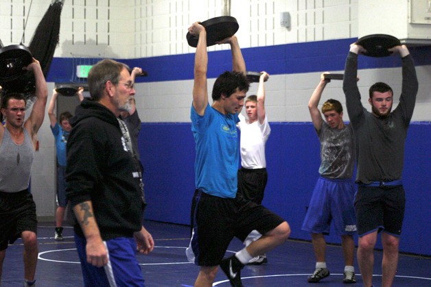 Falcon wrestling coach Jim Thompson instructs the grapplers to keep the weights high. Conditioning and strengthening will be a season-long focus for the wrestling team. Many of the wrestlers entered the season over their preferred weight class.