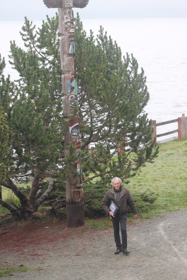 Frank Rose walks along Seawall Park past one of the totem poles. As the chairman of the Langley Arts Commission