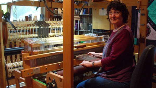 Linda LaMay weaves an alpaca and silk scarf on her 24-shaft AVL loom.