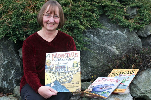 Author Deb Lund shows the collection of children’s books she has written. Lund will be one of the local authors celebrated Saturday