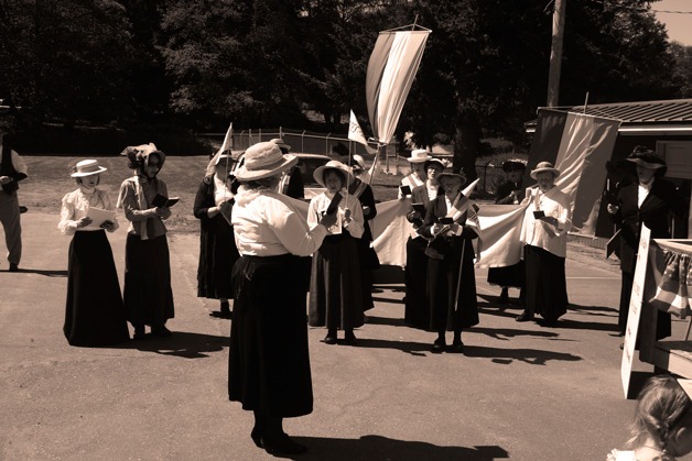 More than 35 women practice suffragette battle songs at the fairgrounds last Sunday. They will sing original suffragette songs as they march through Langley Saturday. The suffragette march is written and directed by Bob Waterman