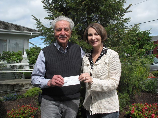 Artist of South Whidbey member Jamie Huden presents a check to Frank Rose