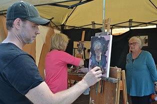 Artist Aaron Coberly paints a portrait of Langley resident Sharen Heath during last year's Choochokam Arts Festival. Faye Castle works in the background.