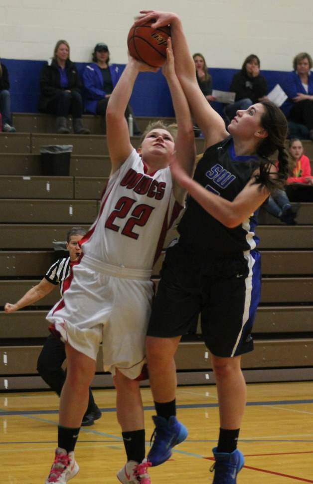 Kacie Hanson blocks a layup attempt by Coupeville senior Madeline Strasburg on Monday. Hanson injured her ankle on the play and missed the rest of the game.